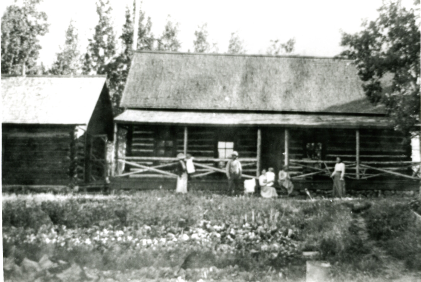 people stand in front of a log cabin