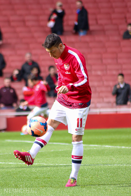 soccer player on field in red uniform kicking ball