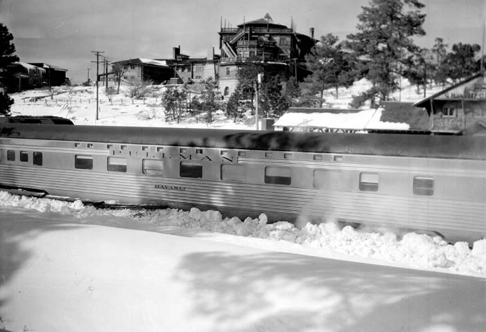 an old train sits on the tracks as the snow drifts
