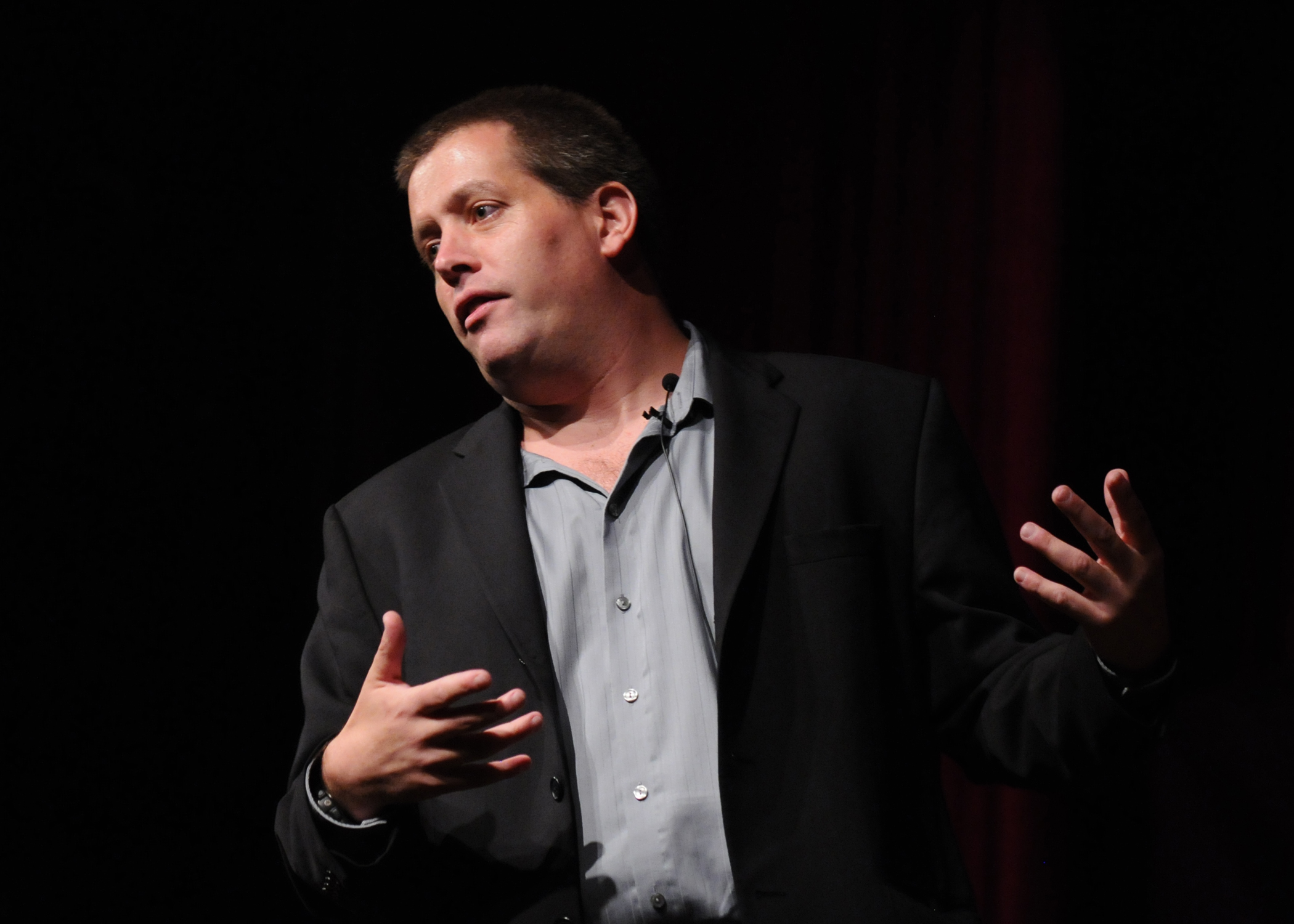 man talking to people in an auditorium