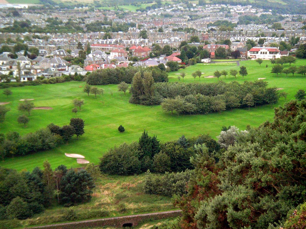 a view of a golf course on the hillside near trees