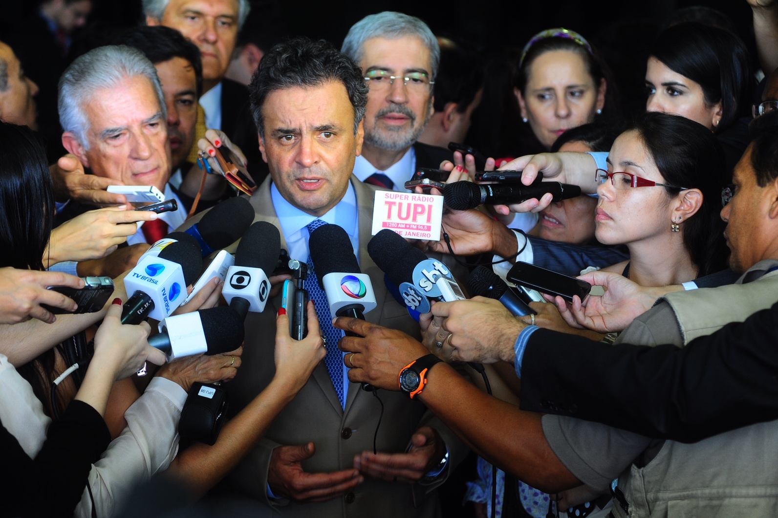 a man surrounded by media and reporters in a crowd