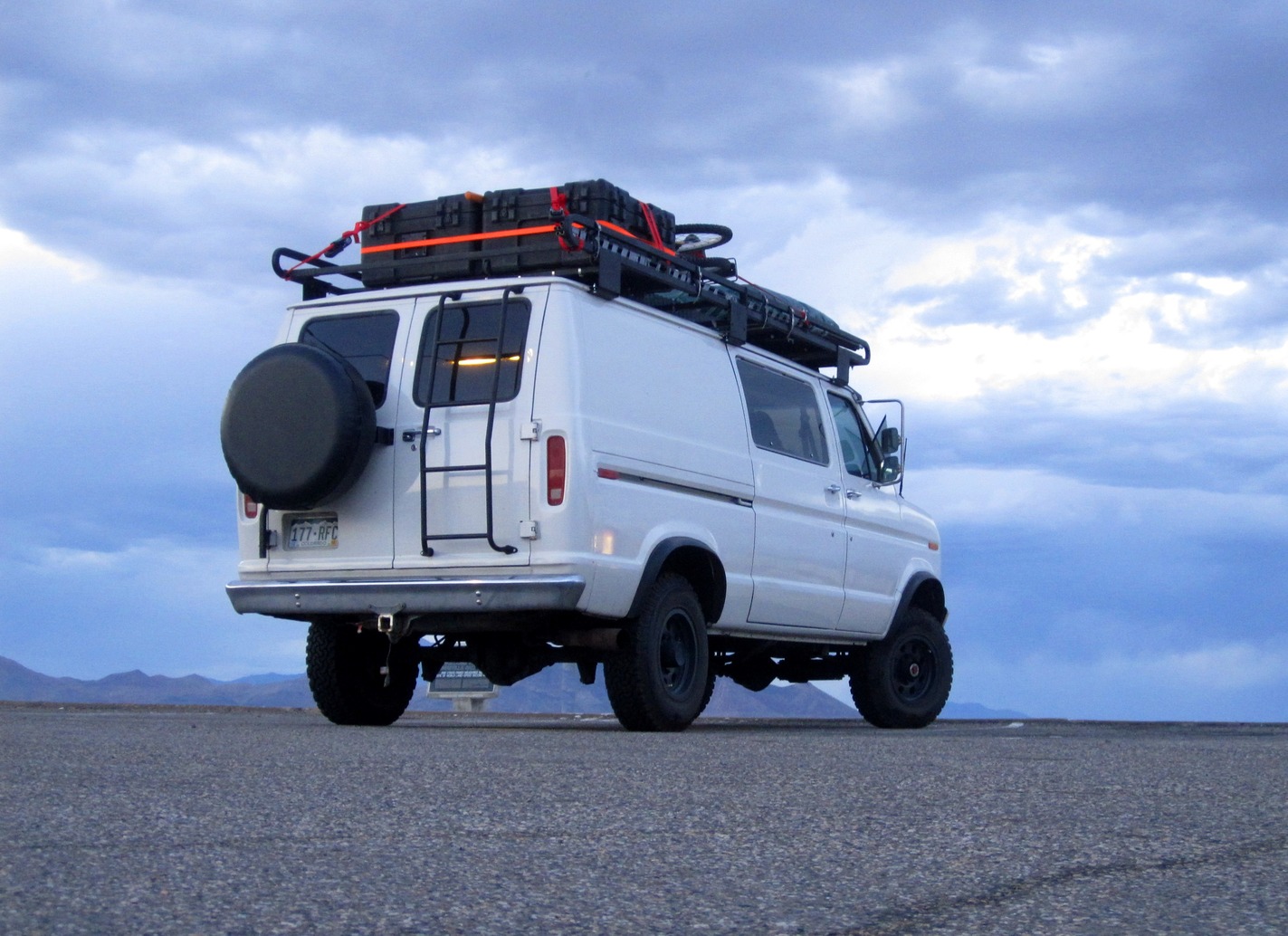 a white van with a rooftop rack is parked