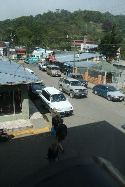 a view from inside a building of a market with parked cars