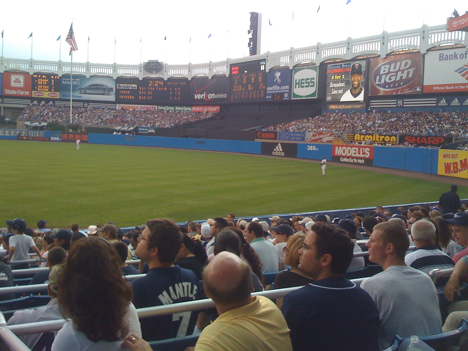 a baseball field filled with fans and a pitcher at a game