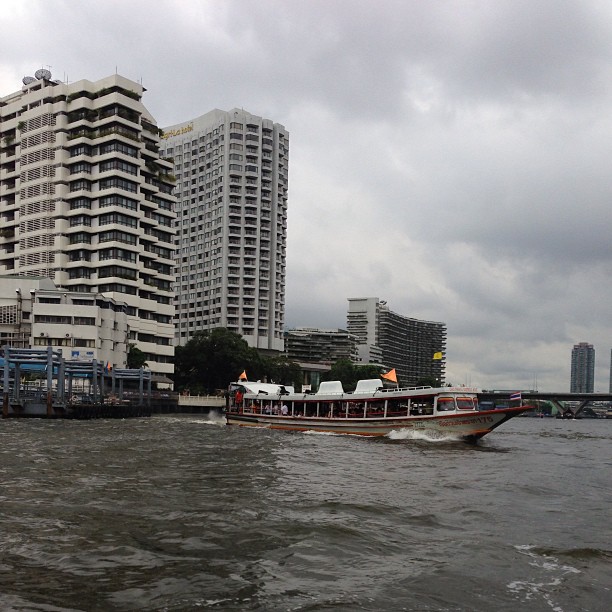 a boat sails down the river past the tall buildings