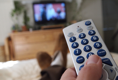 a person holds the remote control for tv in their hand