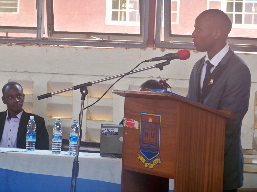 a man speaks into a podium near an empty microphone