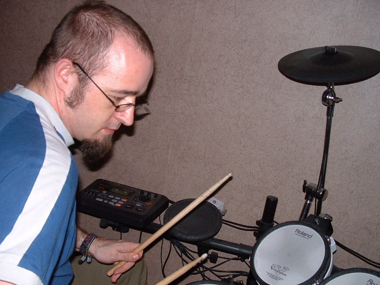 a man is playing drums with a microphone