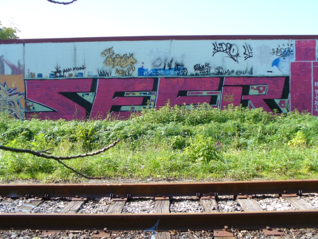 graffiti on a building near train tracks