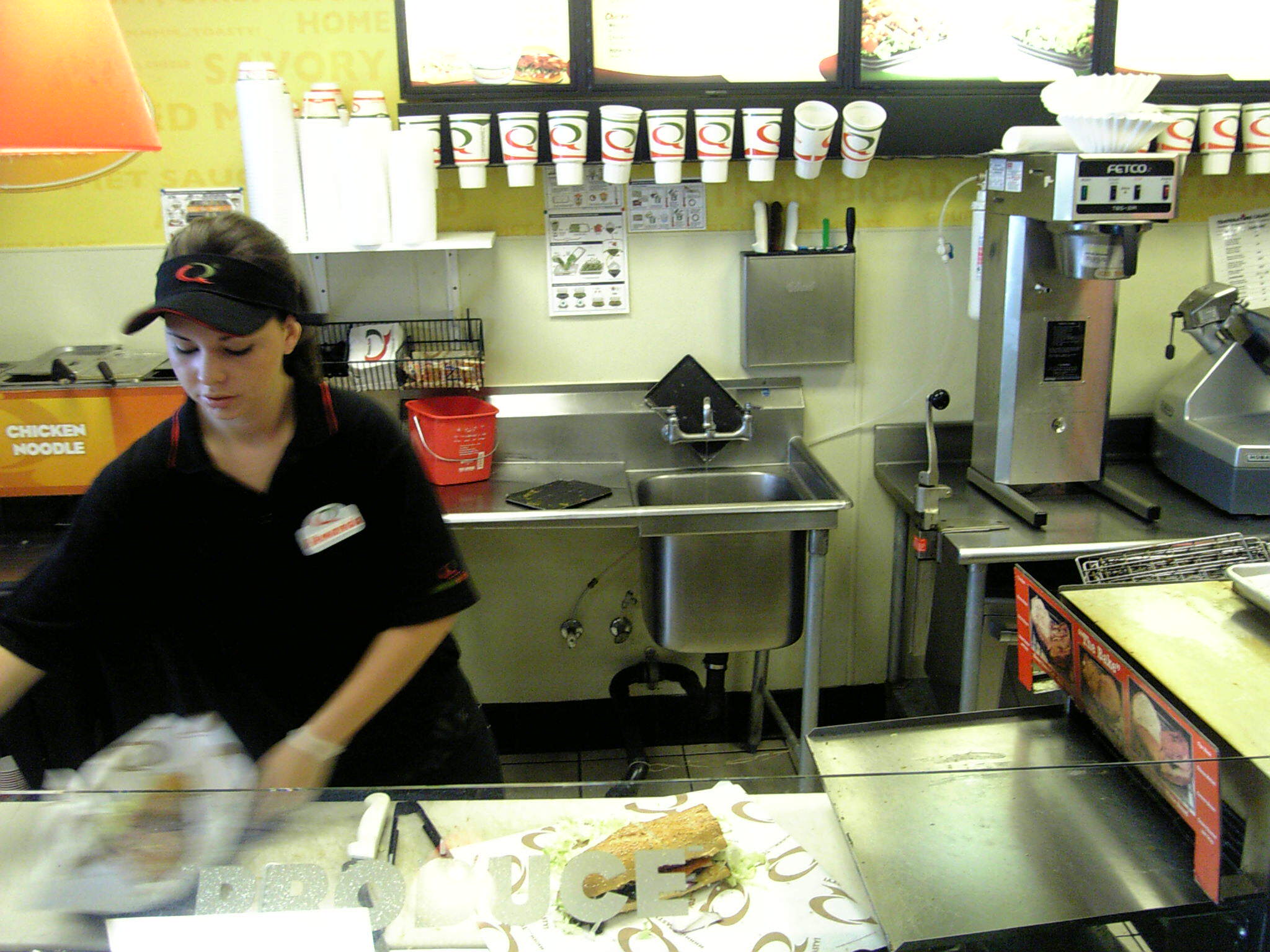 woman with a black hat working in a fast food restaurant