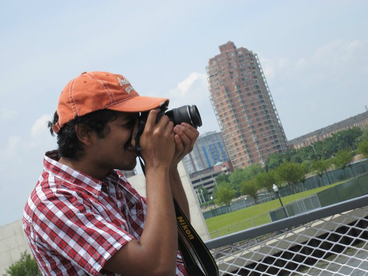 a man holding a camera with a view of city