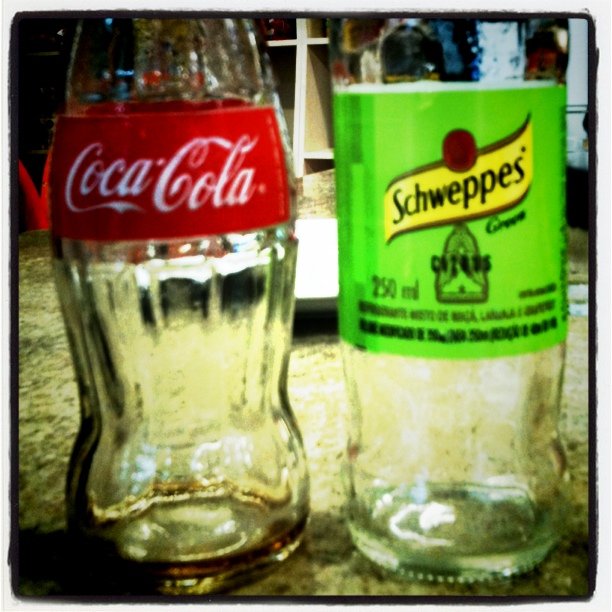 an old and vintage coca - cola bottles are on the counter