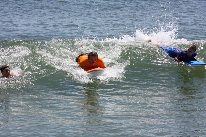 several people laying on their stomachs while riding the waves