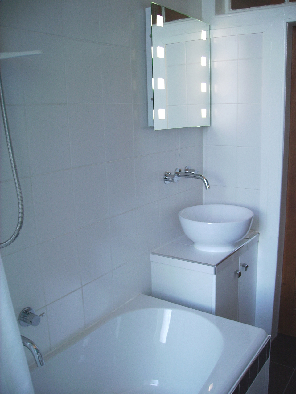 a bathroom with a large bath tub under a bathroom mirror