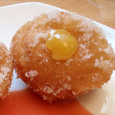 two donuts covered with sugar and a jelly
