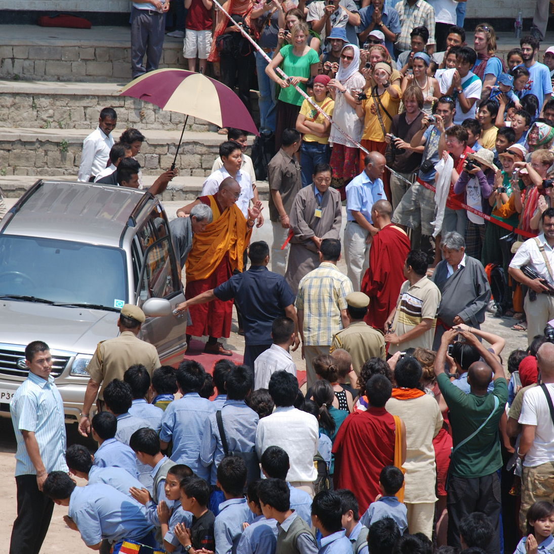 a crowd watching a man standing with an umbrella