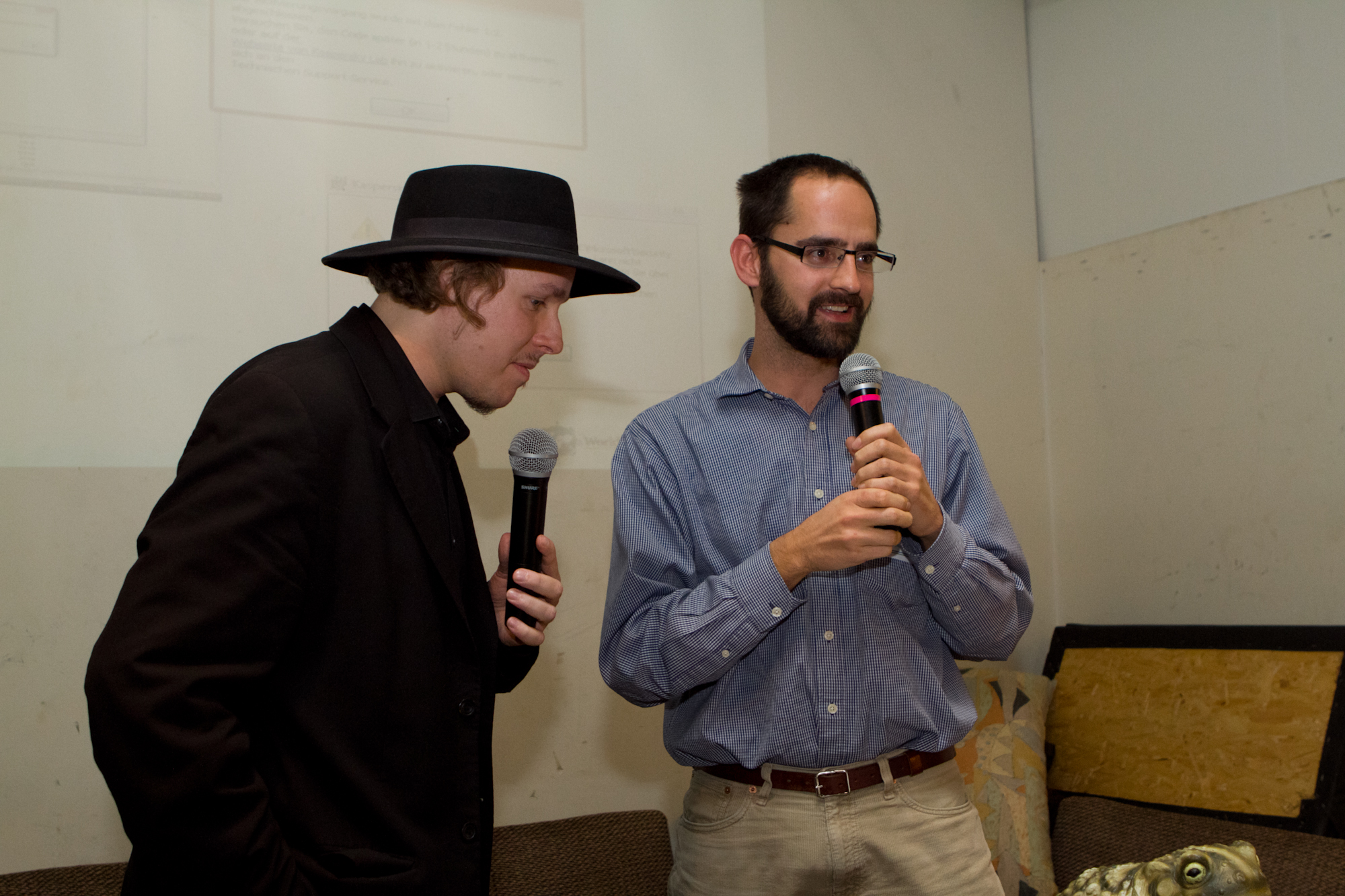 a man with glasses and a black hat on speaking