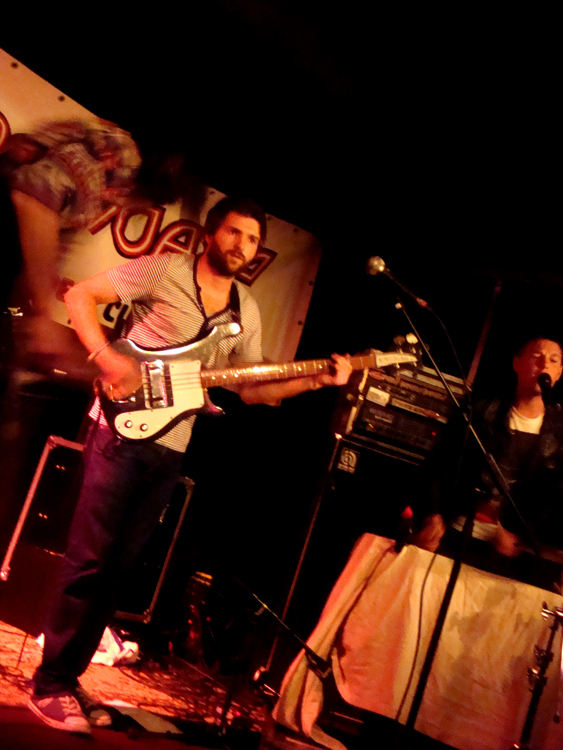 a man playing a guitar and singing at a concert