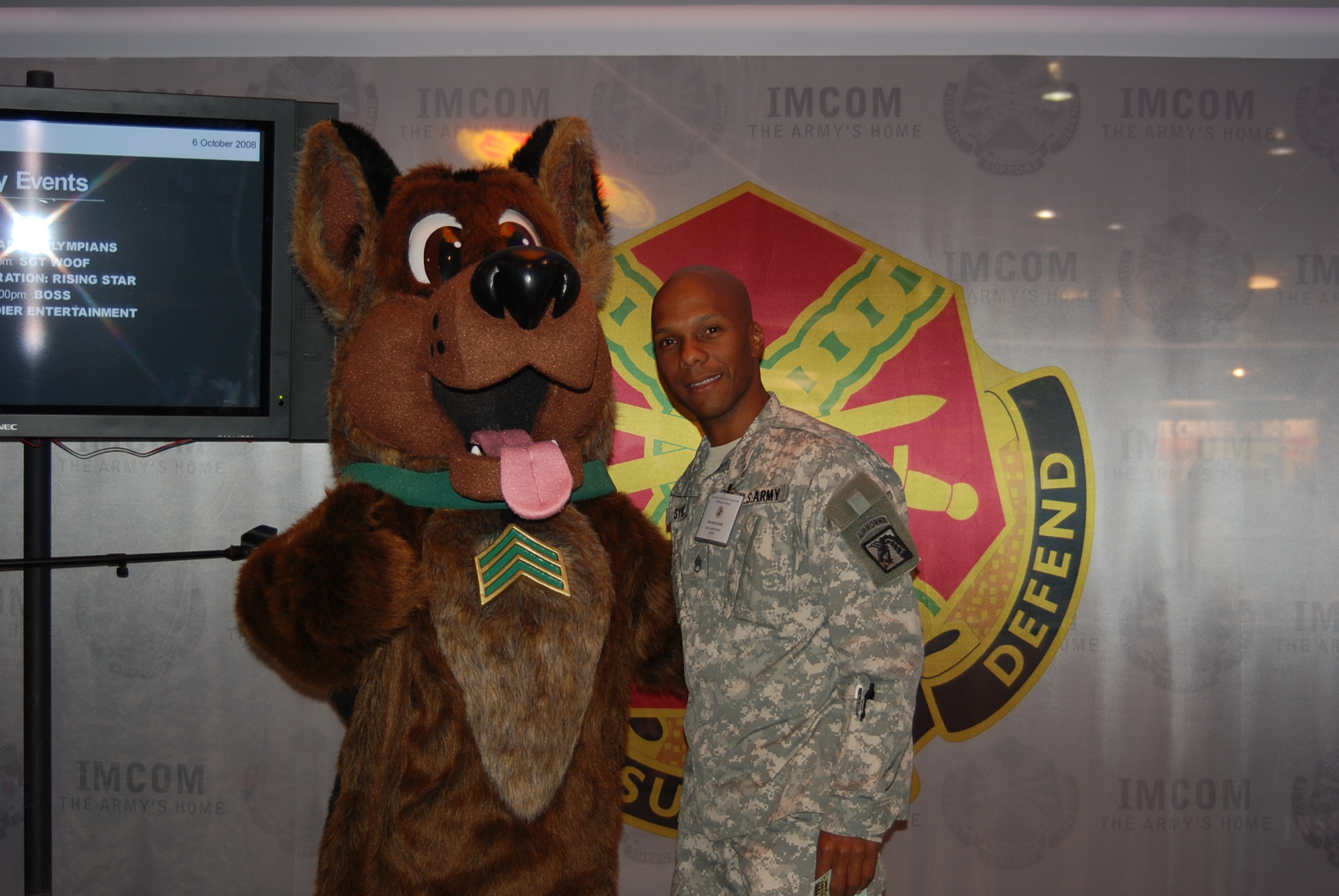 two soldiers are posing in front of the mascot for a picture