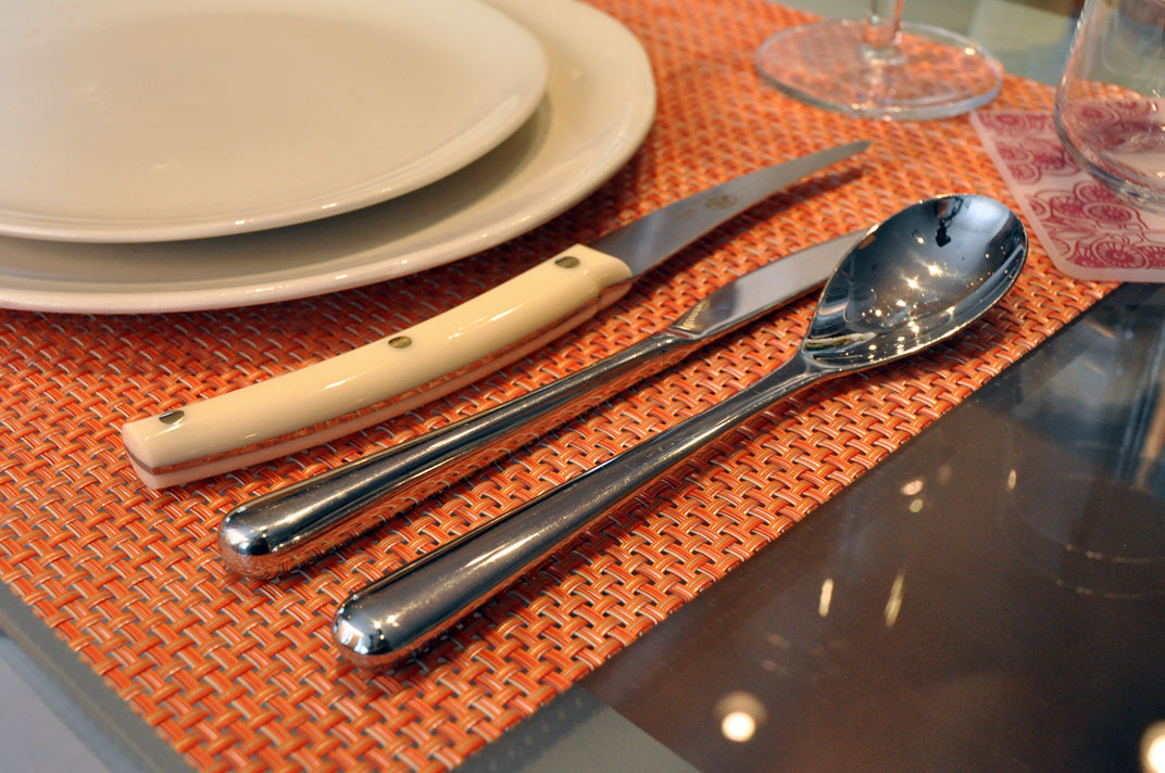 three silverware on top of a orange place mat