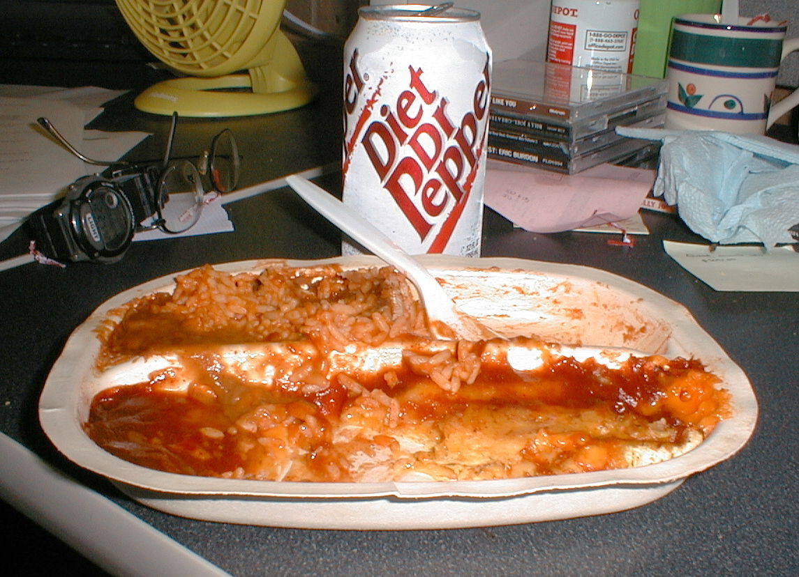 an open pizza dish next to a can of soda