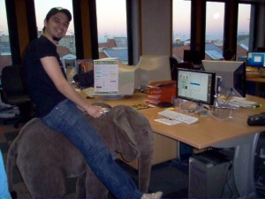 a young man sitting on an elephant toy in an office