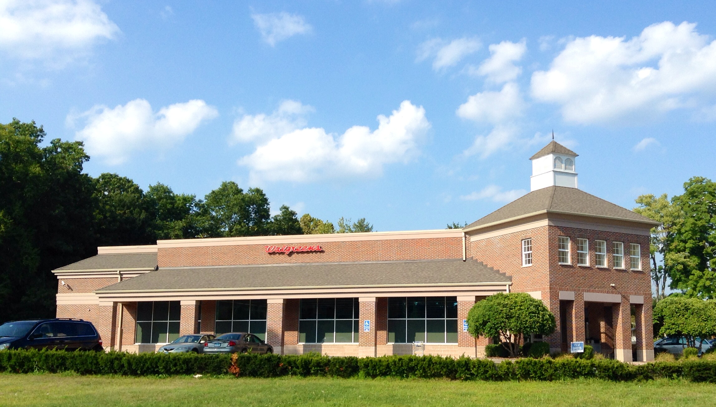 the building has windows and many bushes and trees