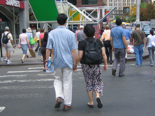 several people walking across a cross walk in the street