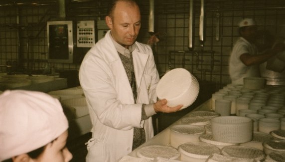 two people standing in a factory looking at plates
