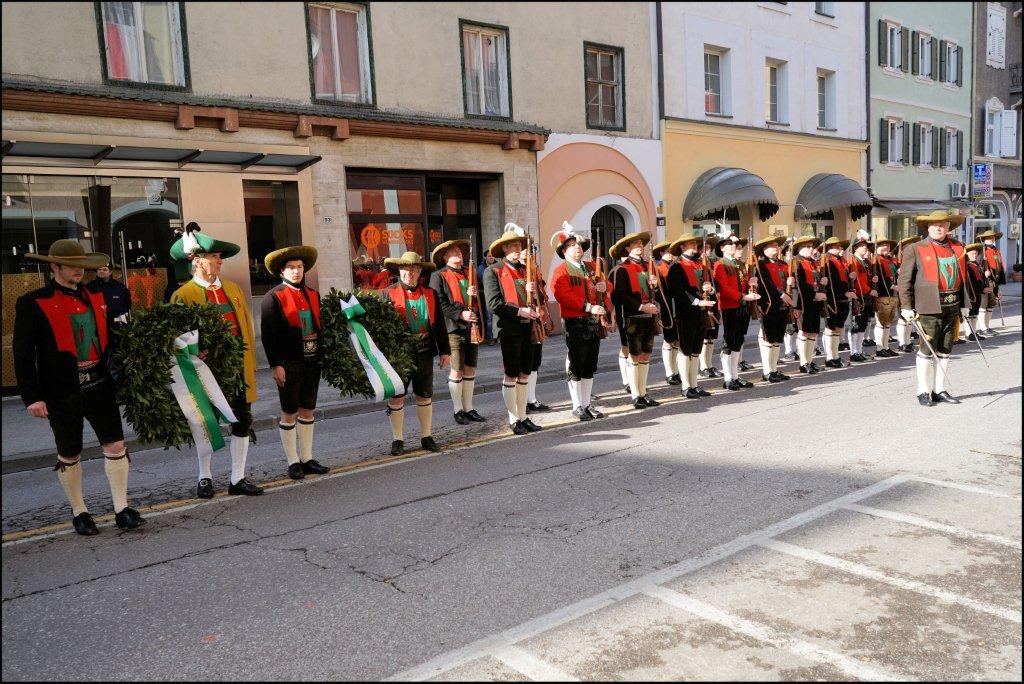 a band of marching men in front of buildings