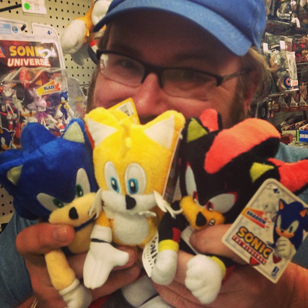 a man is holding a bunch of stuffed animals