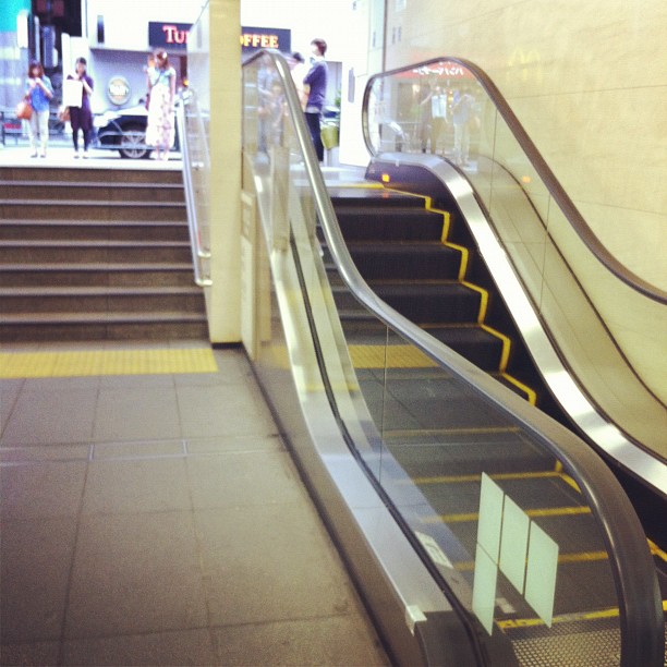 an escalator next to the stairs in a building