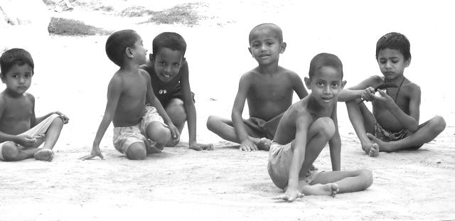 a group of s playing on a sandy beach