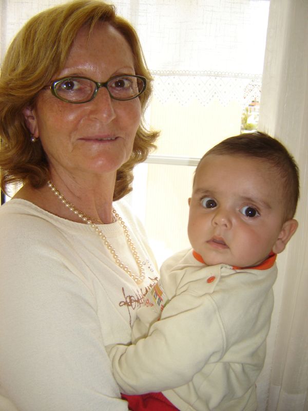 a woman is holding her child in front of a window
