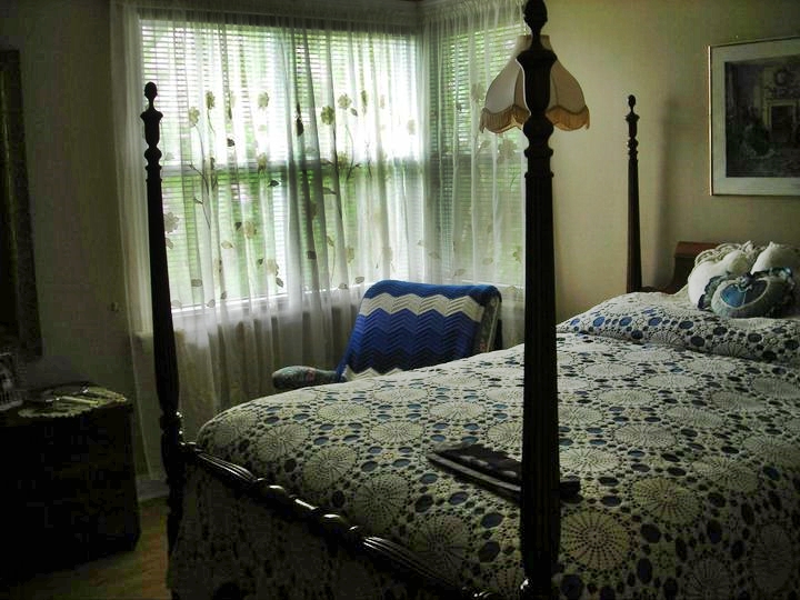 the room has a four post bed and window