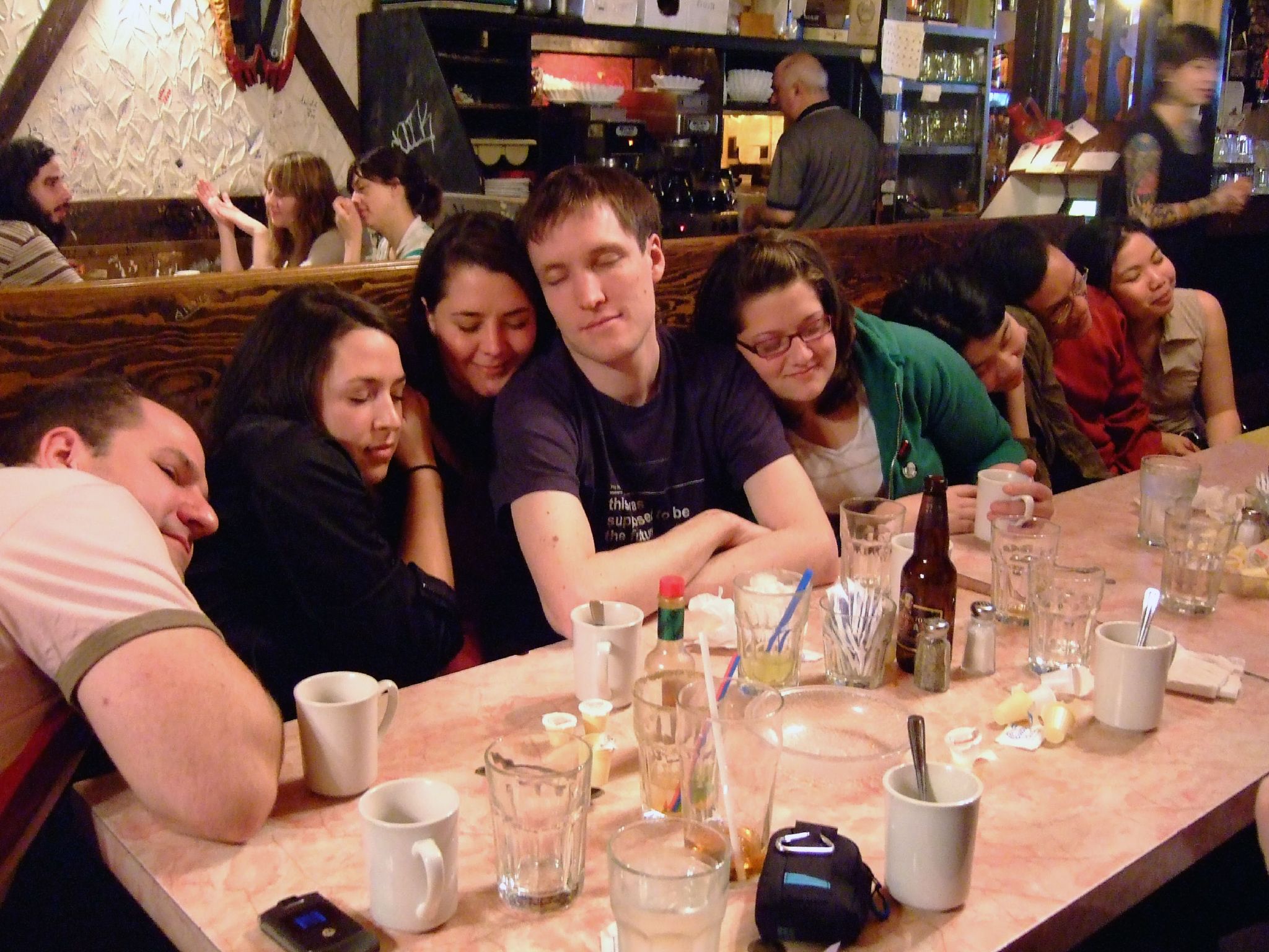 a group of friends sitting at a table in a restaurant