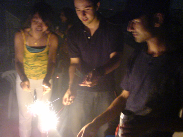 group of friends celeting at birthday party, standing around the cake