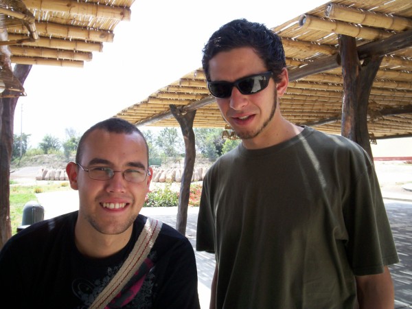 two men standing next to each other wearing sunglasses