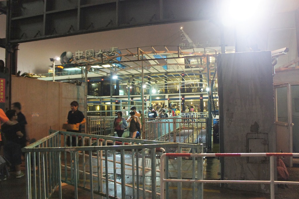 group of people standing near an unfinished structure at night