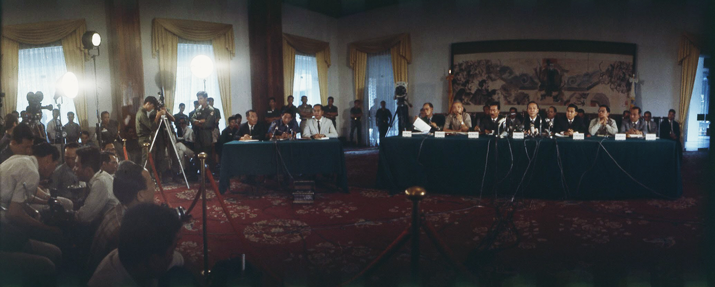 a group of people standing around a long table