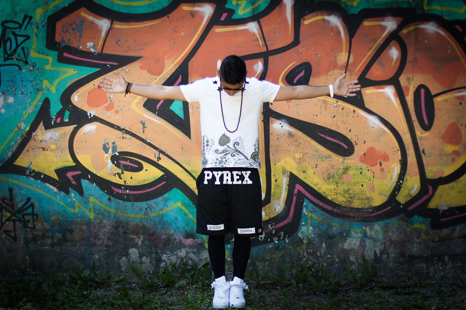 a man standing by some colorful graffiti