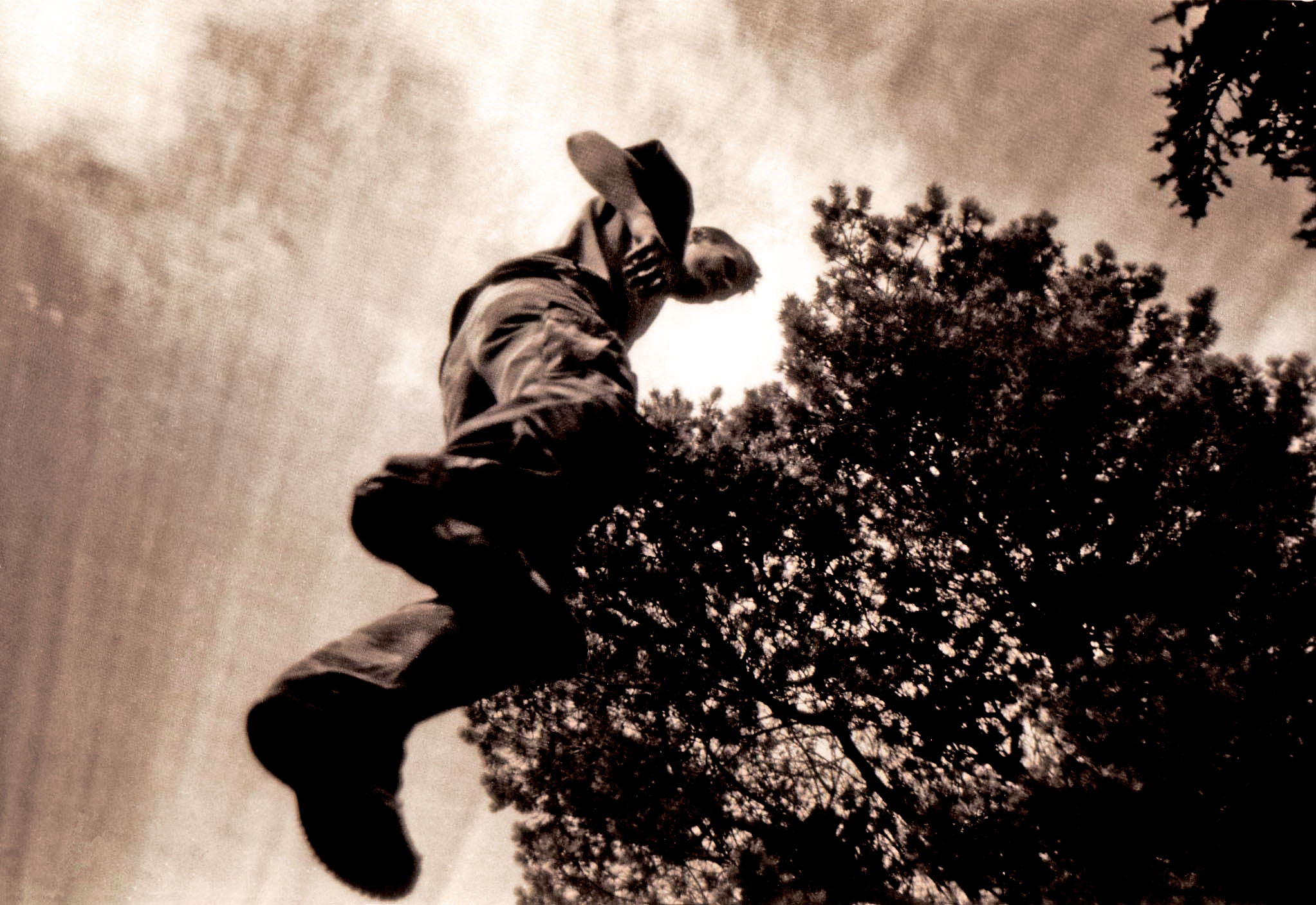 man jumping into the air on skateboard on a cloudy day