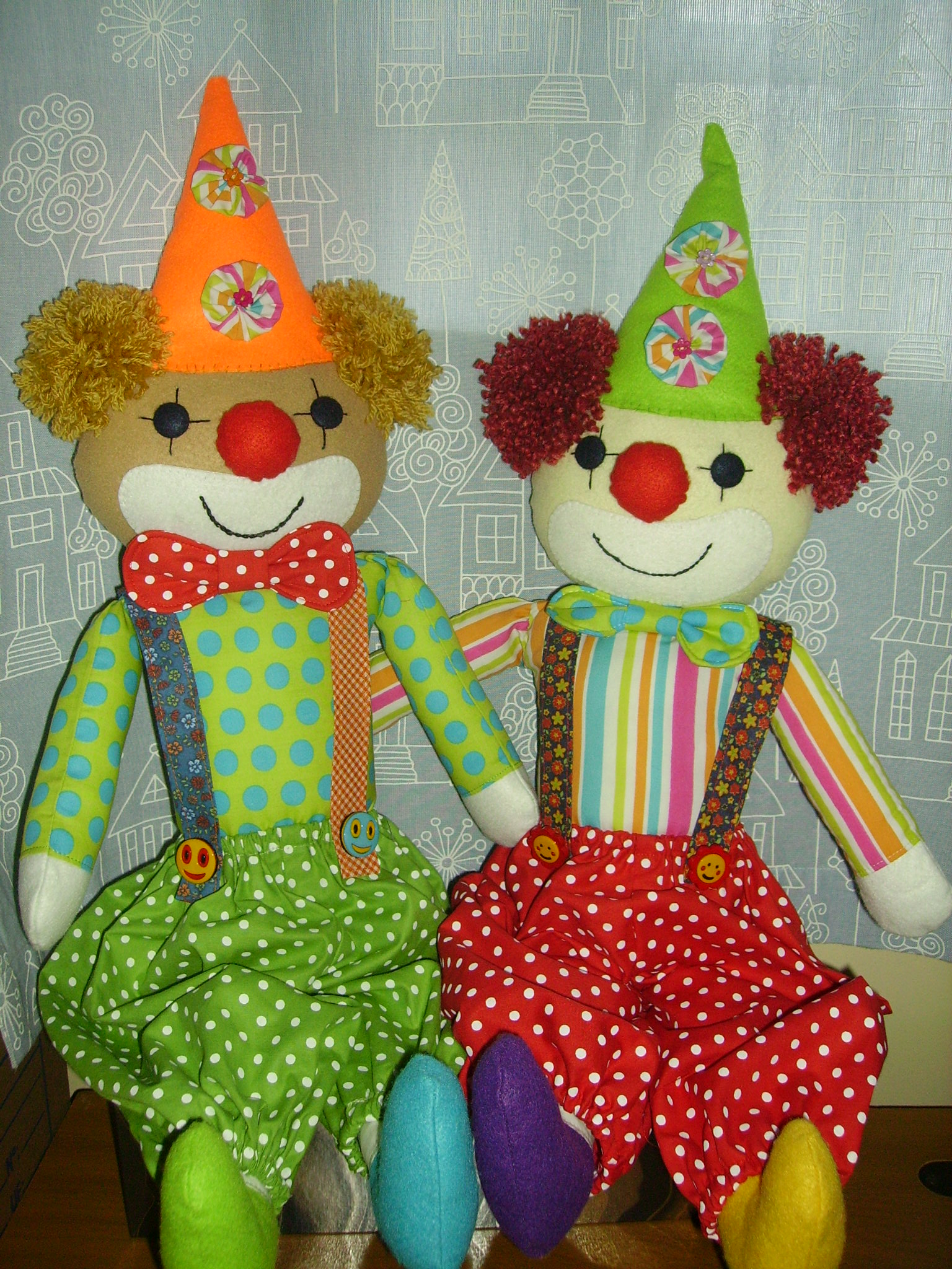 two stuffed animals are wearing party hats and sitting on a shelf