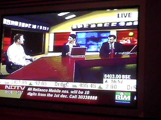 a tv screen showing a news interview on a table