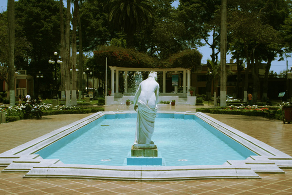 a fountain has a statue in front of it