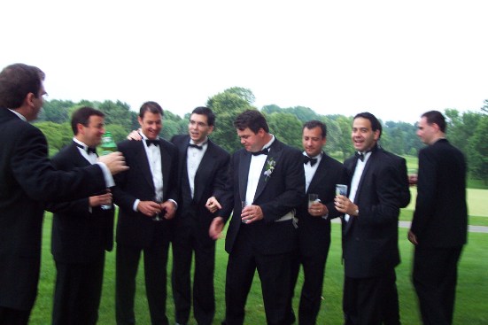 a group of men in tuxedos pose together
