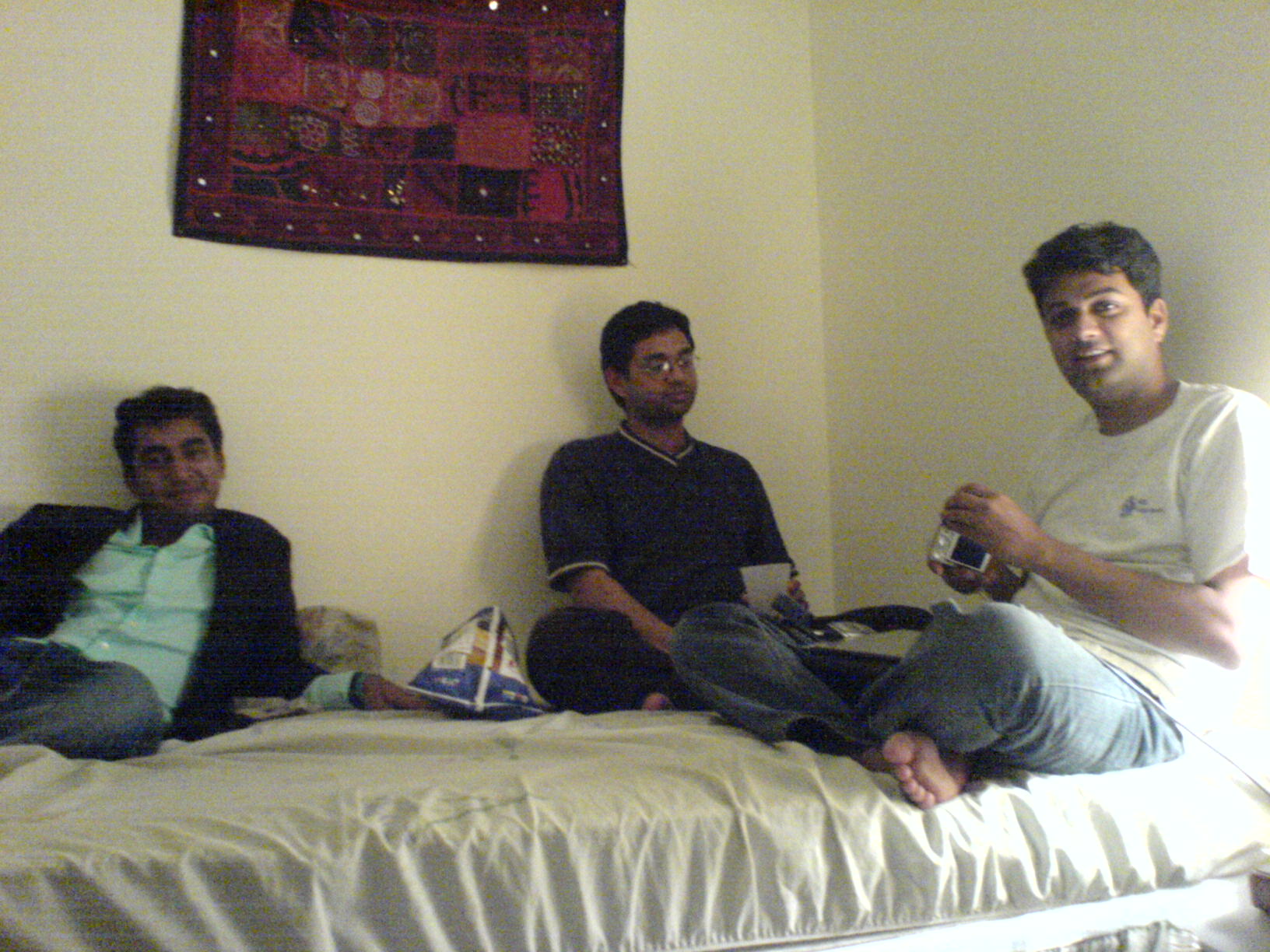 three people on a bed with food in their hand
