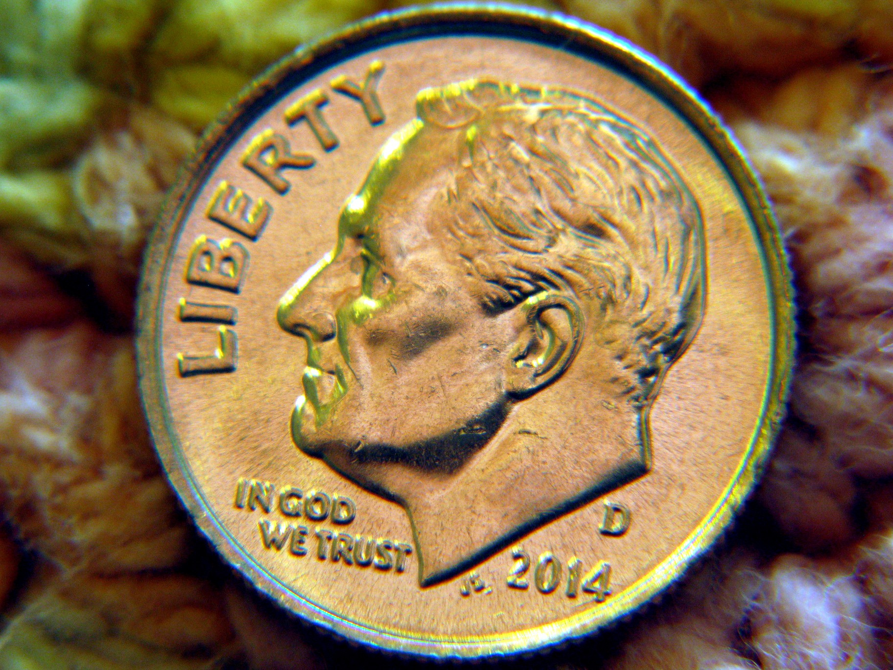 a close up of a gold medal on a teddy bear