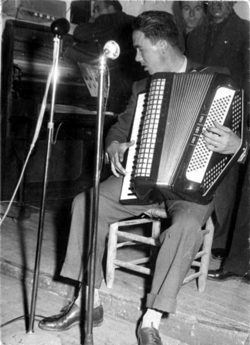 a man sits in front of a microphone while playing the accordion